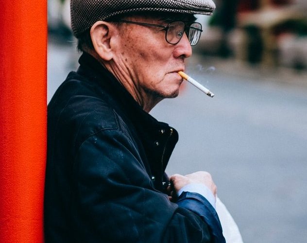 Starší muž s cigaretou v ústech.