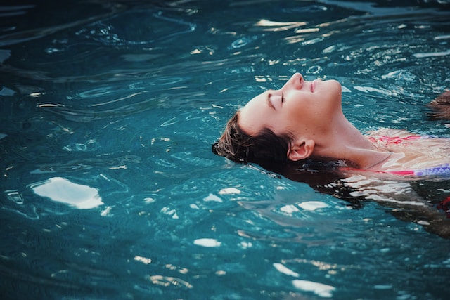 Mladá žena v bazénu.