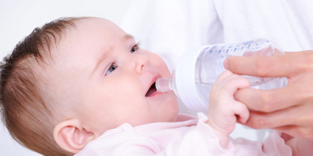 Malé dítě s lahvičkou vody.